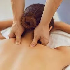 Soin holistique et harmonisation des énergies vitales Application d'un massage énergétique et thérapeutique sur le dos d'une patiente